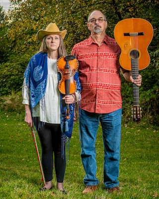 Deb and Greg holding guitars upside down